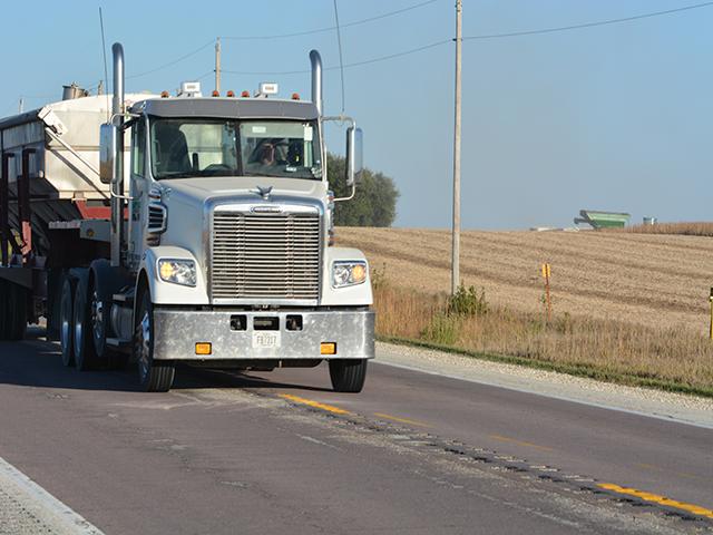 A semi-truck on a rural Iowa highway. A federal lawsuit filed last week in Iowa accuses a pair of Iowa trucking companies of bringing in agricultural guest workers from South Africa to operate long-haul trucks instead of working on livestock operations. (DTN file photo by Chris Clayton)  