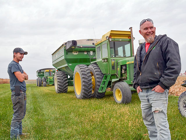 Clayton Loeb, left, of La Porte City, Iowa, and his father, Clint Loeb, take a break during harvest in mid-October. The family predominantly uses John Deere tractors made in the 1960s and 1970s to farm about 1,000 acres of corn. (DTN/Progressive Farmer photo by Matthew Wilde)